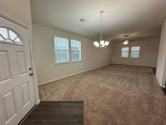 carpeted foyer entrance with ceiling fan with notable chandelier