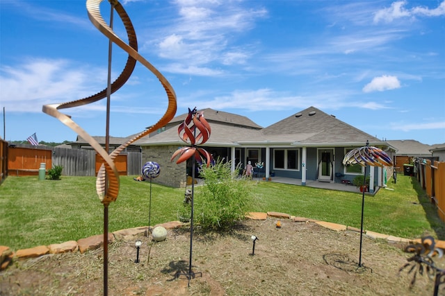 rear view of property with a lawn and a patio