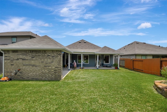 rear view of property with a lawn and a patio