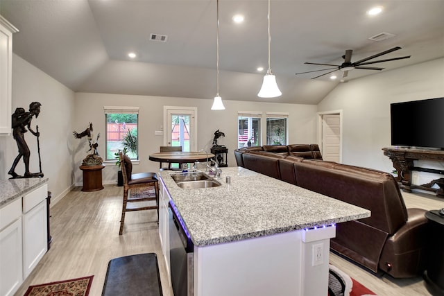 kitchen with hanging light fixtures, vaulted ceiling, white cabinets, dishwasher, and ceiling fan