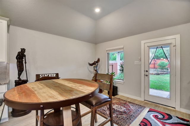 dining room with lofted ceiling and light hardwood / wood-style flooring