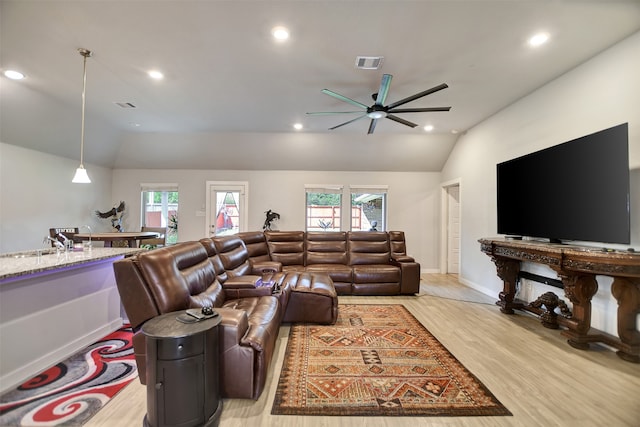 living room with ceiling fan, lofted ceiling, and light hardwood / wood-style floors