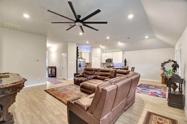 living room with light wood-type flooring, lofted ceiling, and ceiling fan