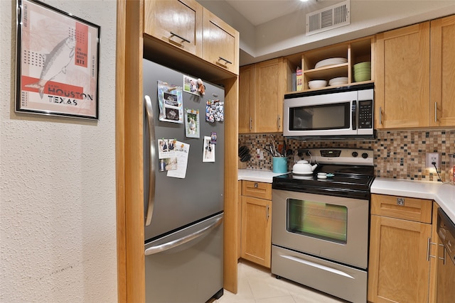 kitchen with appliances with stainless steel finishes, tasteful backsplash, and light tile patterned floors