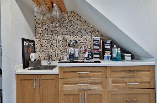 bar with decorative backsplash, sink, black gas stovetop, and vaulted ceiling