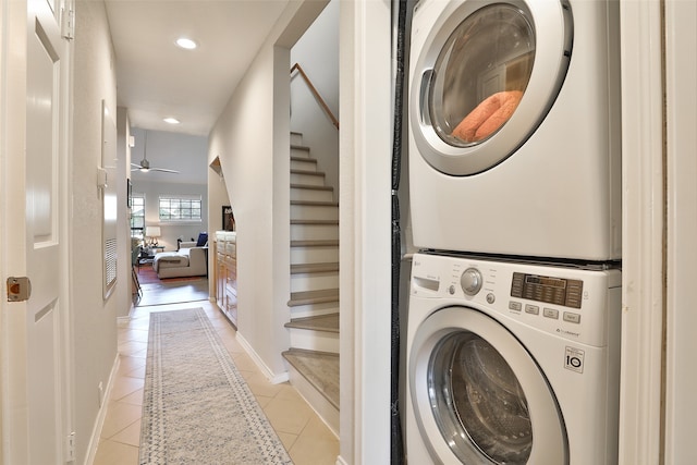 clothes washing area featuring light tile patterned floors, ceiling fan, and stacked washer / drying machine