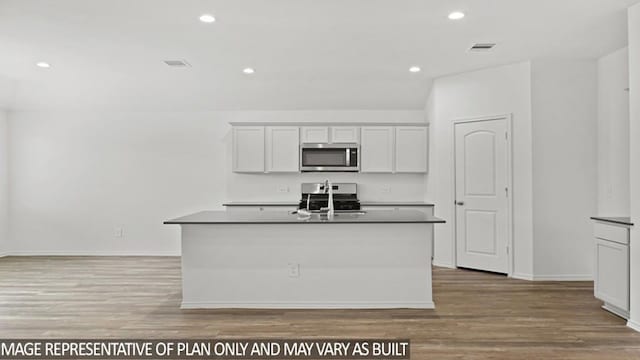 kitchen with sink, light wood-type flooring, a kitchen island with sink, and appliances with stainless steel finishes