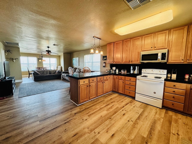 kitchen with ceiling fan, electric range, light hardwood / wood-style floors, a textured ceiling, and kitchen peninsula