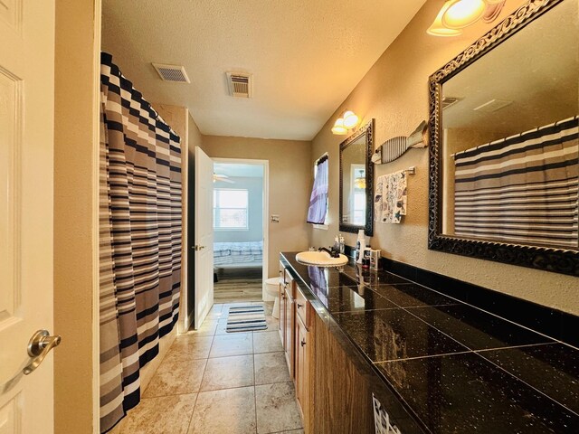 bathroom featuring tile patterned floors, vanity, and a textured ceiling