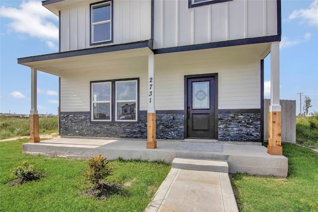 property entrance featuring a porch and a yard