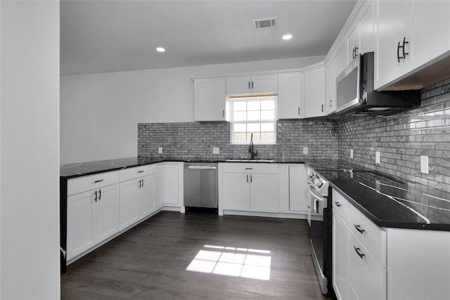 kitchen featuring stainless steel appliances, white cabinets, sink, decorative backsplash, and dark hardwood / wood-style floors