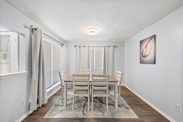 dining area with dark hardwood / wood-style flooring and a textured ceiling