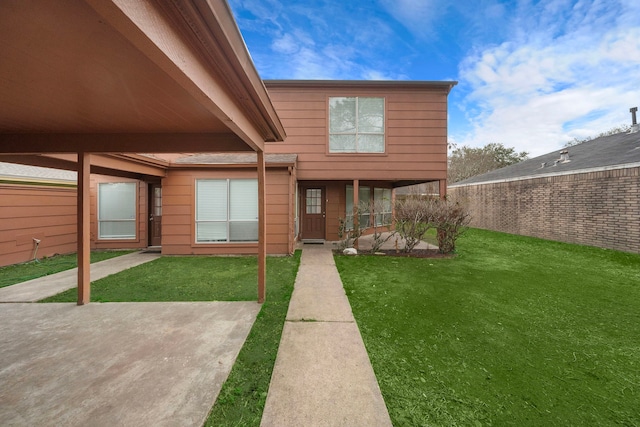 view of front facade featuring a patio, a front yard, and fence