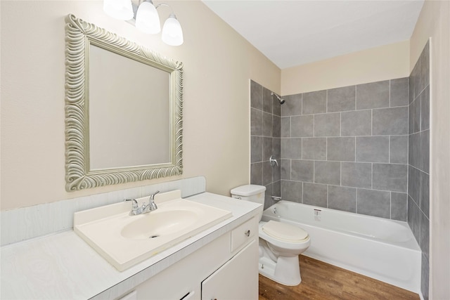 full bathroom with hardwood / wood-style floors, toilet, vanity, and tiled shower / bath