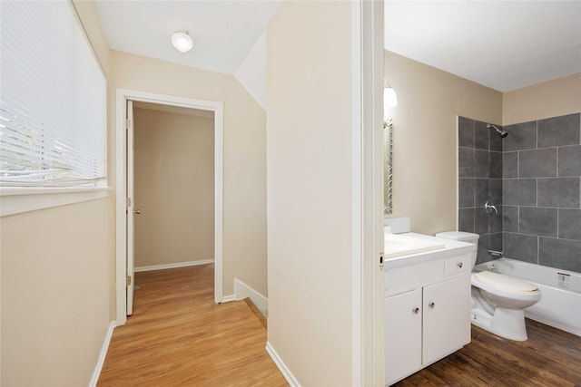 full bathroom with hardwood / wood-style flooring, toilet, vanity, and tiled shower / bath