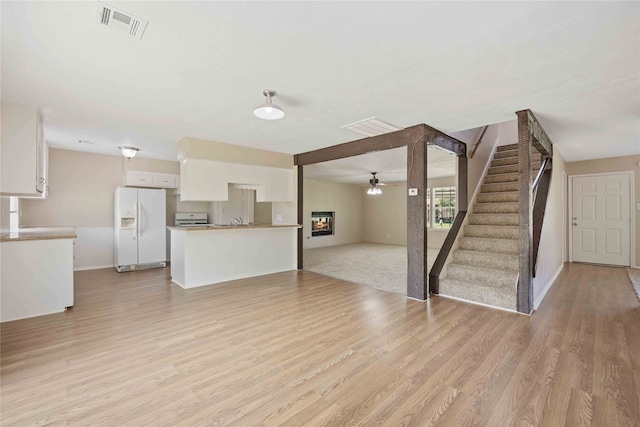 unfurnished living room featuring light hardwood / wood-style flooring and ceiling fan