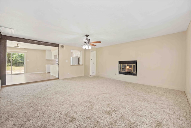 unfurnished living room featuring carpet flooring and ceiling fan