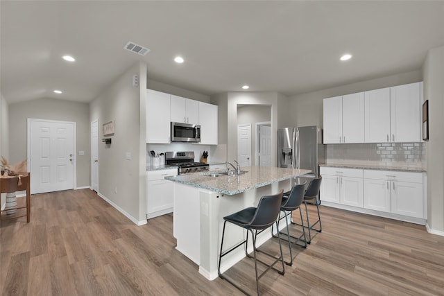 kitchen with a kitchen island with sink, light hardwood / wood-style flooring, appliances with stainless steel finishes, and white cabinets