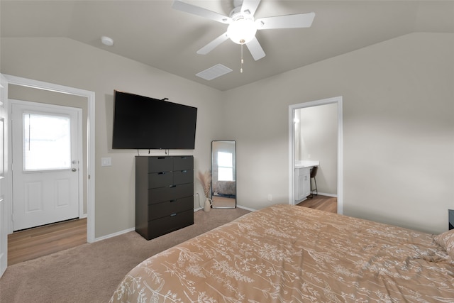 bedroom featuring lofted ceiling, light colored carpet, ensuite bathroom, and ceiling fan