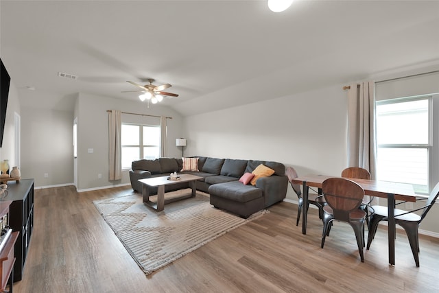 living room with light wood-type flooring, ceiling fan, and vaulted ceiling