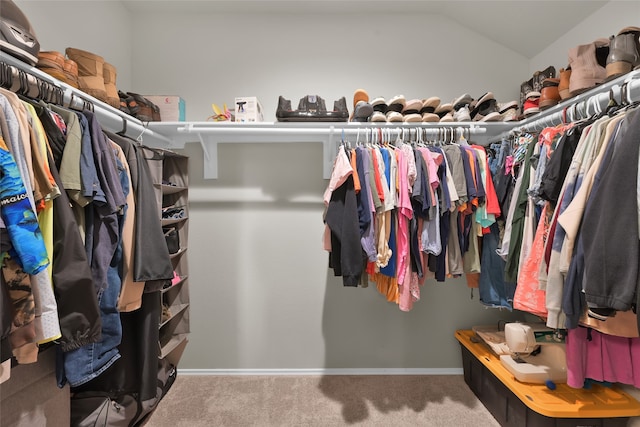 walk in closet with lofted ceiling and carpet flooring