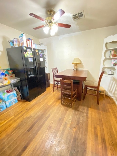 dining area with light wood-type flooring and ceiling fan