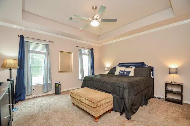 carpeted bedroom featuring ceiling fan, a raised ceiling, and multiple windows