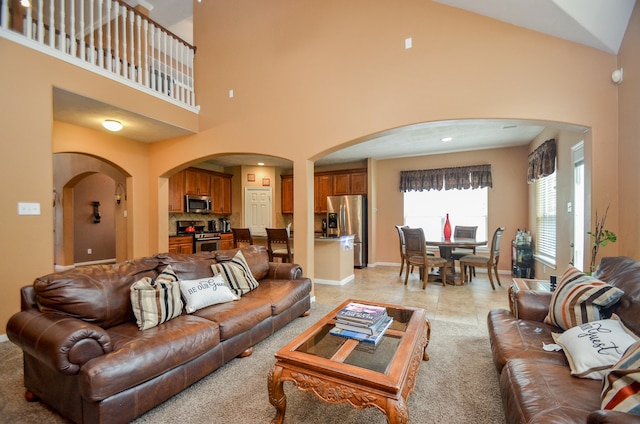 living room featuring a towering ceiling and light tile patterned flooring