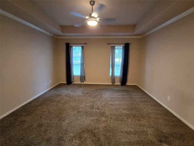 carpeted spare room with a raised ceiling, ceiling fan, and ornamental molding