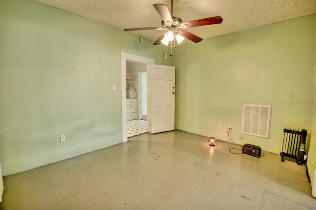 empty room with a textured ceiling and ceiling fan