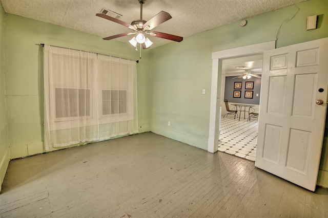 tiled empty room featuring a textured ceiling and ceiling fan