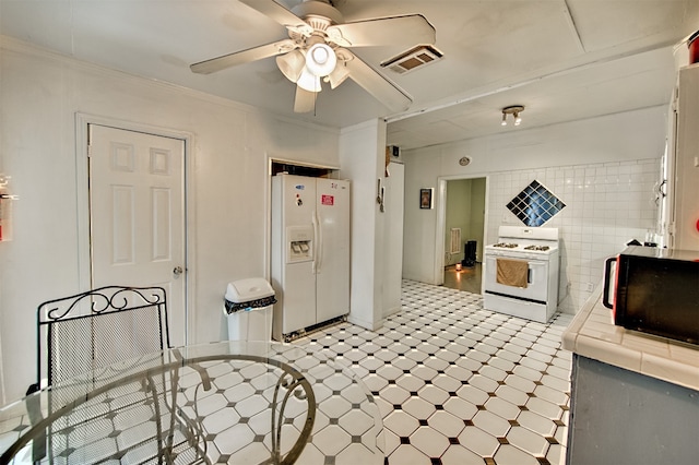 kitchen with white appliances, tile walls, light tile patterned floors, tile counters, and ceiling fan