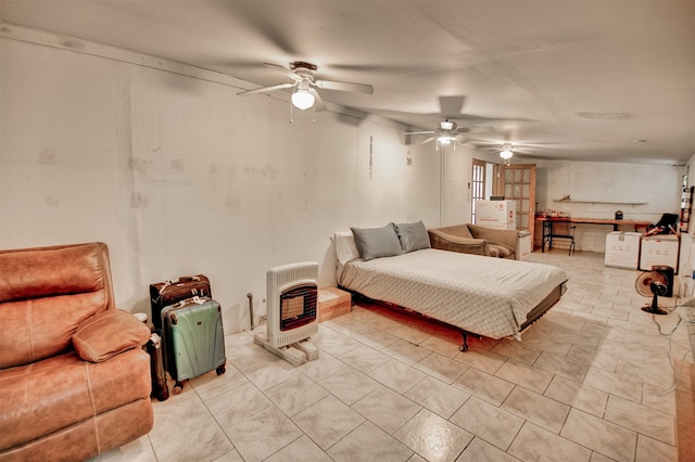 bedroom featuring a wood stove, light tile patterned floors, and ceiling fan