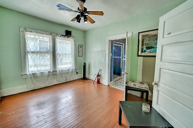 interior space with ceiling fan and wood-type flooring