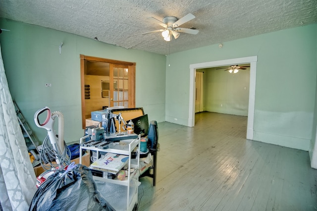 interior space with hardwood / wood-style flooring, a textured ceiling, and ceiling fan