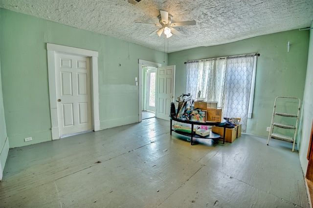 misc room with ceiling fan and a textured ceiling