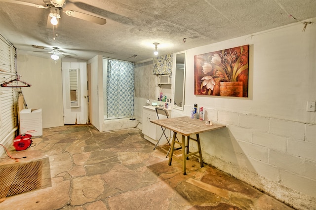 basement with a textured ceiling and ceiling fan