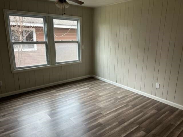 spare room with plenty of natural light, ceiling fan, and hardwood / wood-style flooring