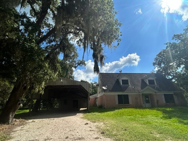 view of front of property featuring a carport and a front lawn