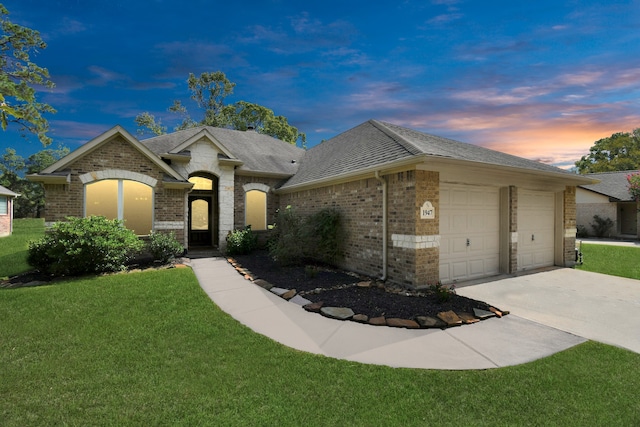 view of front facade with a yard and a garage