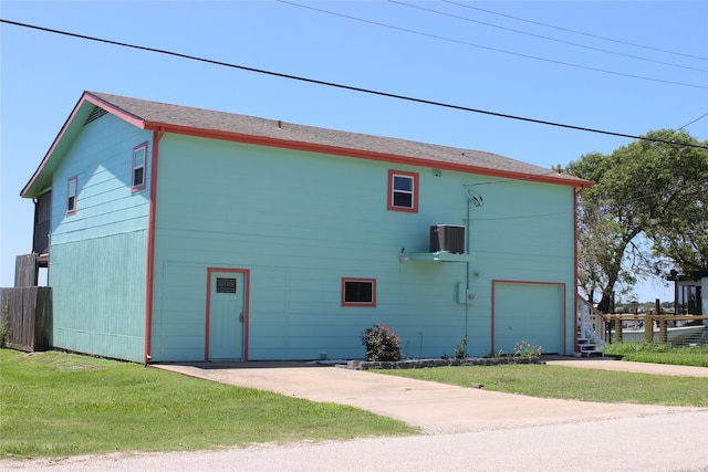 view of building exterior with a garage and central AC