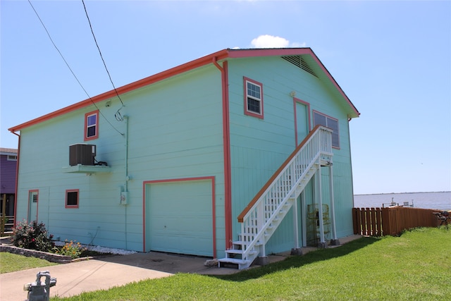 view of side of property featuring a water view and a lawn