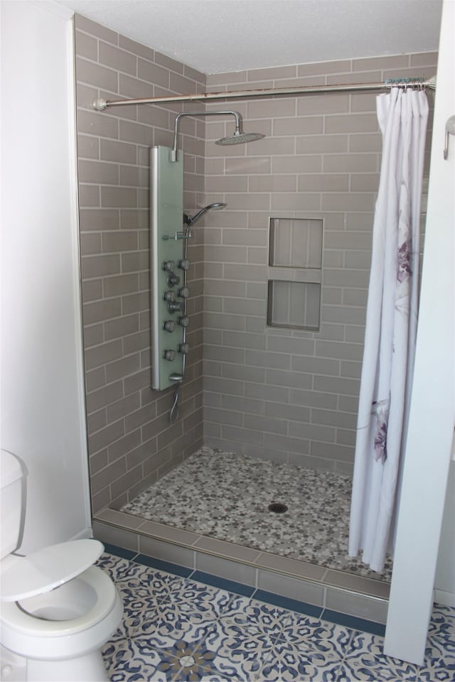 bathroom with walk in shower, toilet, and tile patterned floors