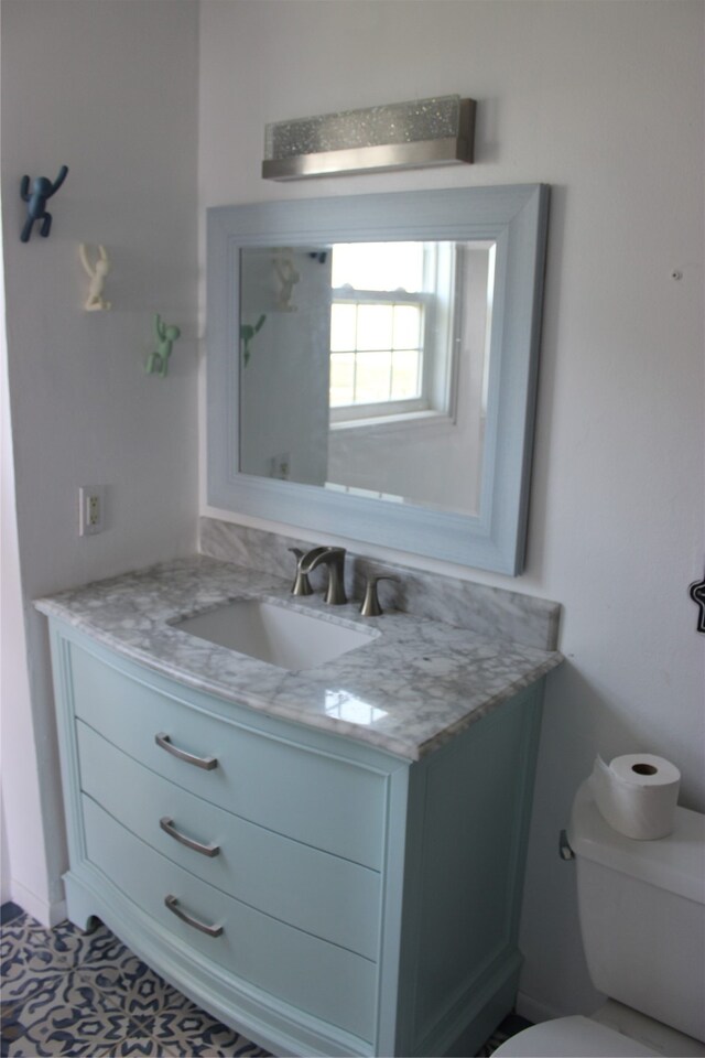 bathroom with tile patterned flooring, toilet, and vanity