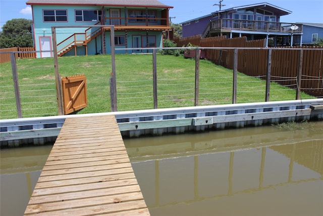 dock area with a water view and a yard