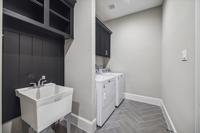 laundry area with separate washer and dryer, sink, and cabinets