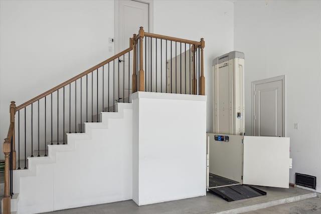 staircase featuring a towering ceiling