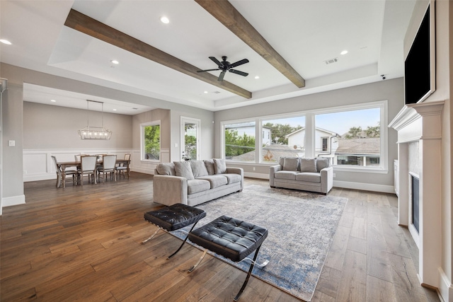 living room with hardwood / wood-style flooring, ceiling fan, and beam ceiling