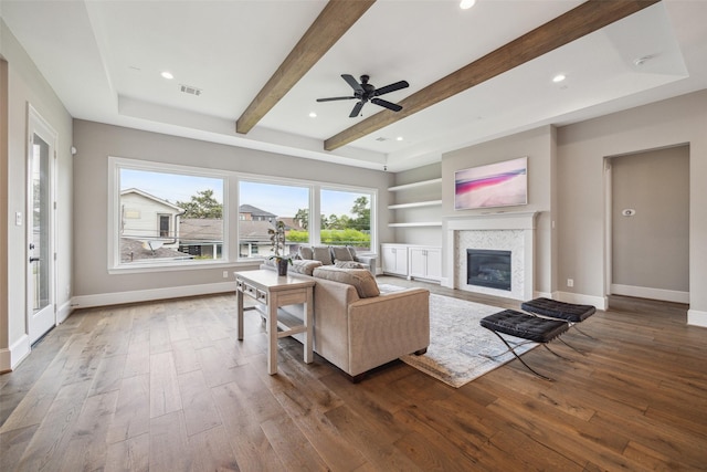 living room with hardwood / wood-style flooring, beam ceiling, ceiling fan, and built in shelves