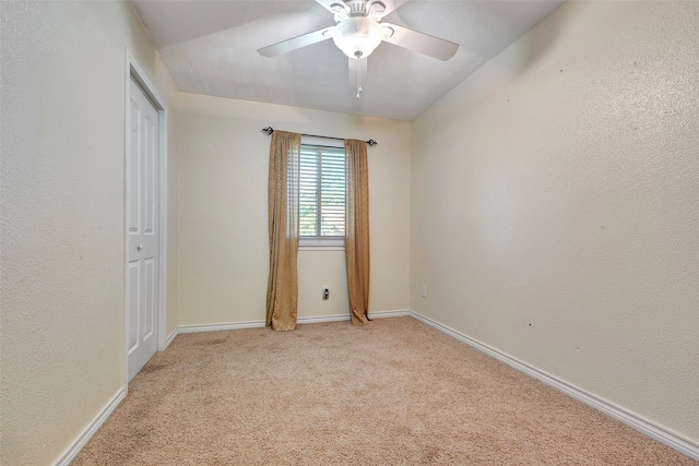 carpeted spare room with ceiling fan